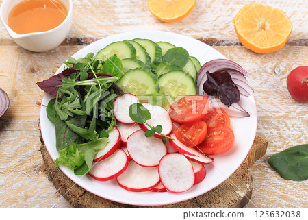 Green vegetable salad with cherry tomatoes, cucumber, radish and fresh arugula, detox diet. Healthy natural breakfast for weight loss, cholesterol and GMO free, selective focus, rustic style, place Green vegetable salad with cherry tomatoes, cucumber, radish and fresh arugula, detox diet. Healthy natural breakfast for weight loss, cholesterol and GMO free, selective focus, rustic style, place 125632038
