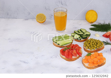 Fried bread, carrots, and cucumbers, tomatoes and peas with lemon juice, green sandwiches, the concept of a healthy diet and weight loss, healthy diet foods on a light background, I love my body. 125632042