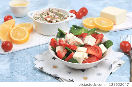 Vegetable salad with mozzarella cheese, cherry tomatoes and fresh arugula, Healthy natural breakfast with lemon, detox diet. Traditional Italian food, cholesterol and GMO free, selective focus, space Vegetable salad with mozzarella cheese, cherry tomatoes and fresh arugula, Healthy natural breakfast with lemon, detox diet. Traditional Italian food, cholesterol and GMO free, selective focus, space 125632047