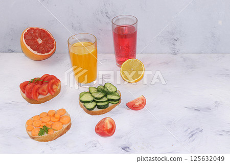 Fried bread, carrots, and cucumbers, tomatoes and peas with lemon and grapefruit juice, green sandwiches, the concept of a healthy diet and weight loss, healthy diet foods on a light background, I Fried bread, carrots, and cucumbers, tomatoes and peas with lemon and grapefruit juice, green sandwiches, the concept of a healthy diet and weight loss, healthy diet foods on a light background, I 125632049