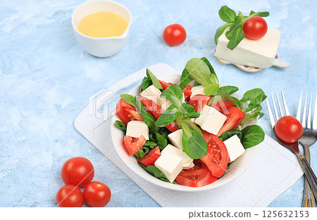 Caprese with mozzarella cheese, cherry tomatoes and fresh arugula, Useful natural breakfast with lemon, detox diet.Traditional Italian food,, cholesterol-free and GMO-free, selective focus, place for Caprese with mozzarella cheese, cherry tomatoes and fresh arugula, Useful natural breakfast with lemon, detox diet.Traditional Italian food,, cholesterol-free and GMO-free, selective focus, place for 125632153
