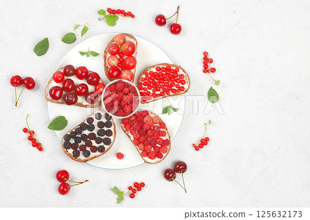 Diet fruit mini sandwiches with soft cottage cheese and fresh berries, raspberries, currants and cherries, a healthy breakfast with ingredients. The concept of healthy and natural food, lifestyle, Diet fruit mini sandwiches with soft cottage cheese and fresh berries, raspberries, currants and cherries, a healthy breakfast with ingredients. The concept of healthy and natural food, lifestyle, 125632173