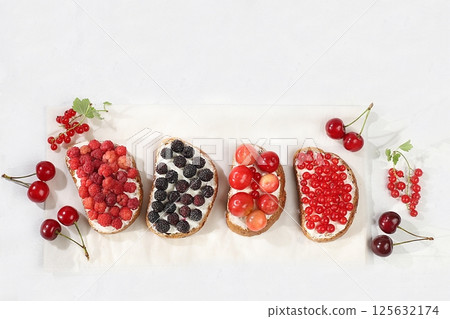 Healthy breakfast with ingredients. Diet fruit mini sandwiches with soft cottage cheese and fresh berries, raspberries, currants and cherries, The concept of healthy and natural food, lifestyle, flat 125632174