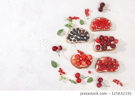 Healthy breakfast with ingredients. Diet fruit mini sandwiches with soft cottage cheese and fresh berries, raspberries, currants and cherries, The concept of healthy and natural food, lifestyle, flat Healthy breakfast with ingredients. Diet fruit mini sandwiches with soft cottage cheese and fresh berries, raspberries, currants and cherries, The concept of healthy and natural food, lifestyle, flat 125632191