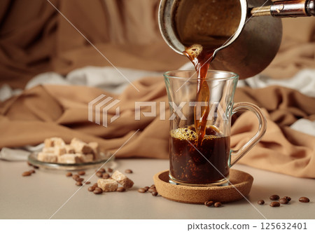 Pour the black coffee into a cup. 125632401
