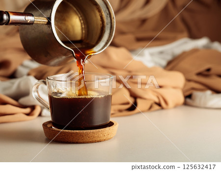Pour the black coffee into a cup. 125632417