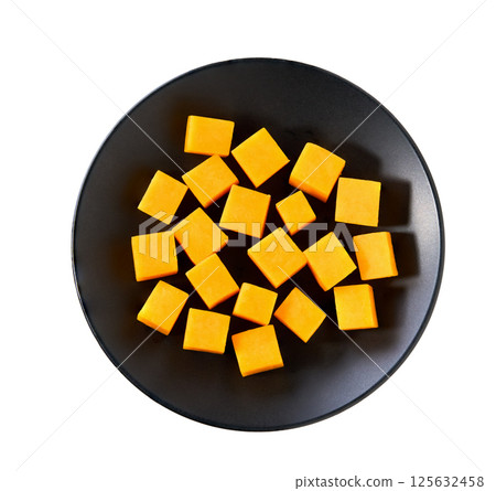 cheddar cheese cut into cubes in black plate isolated on white background, top view. cheddar cheese cut into cubes in black plate isolated on white background, top view. 125632458