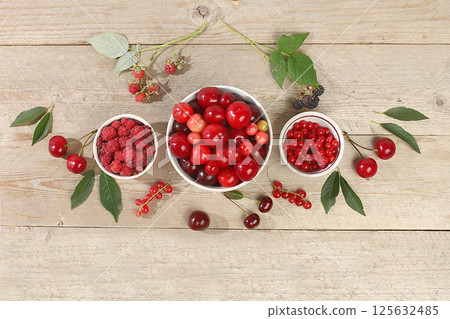 Summer fresh cherries, currants and raspberries on a wooden background with leaves, harvesting in the village, healthy natural food concept, breakfast with ingredients, banner and shop advertisement, Summer fresh cherries, currants and raspberries on a wooden background with leaves, harvesting in the village, healthy natural food concept, breakfast with ingredients, banner and shop advertisement, 125632485
