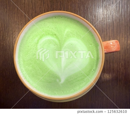 hot green tea with milk and colored foam 125632610