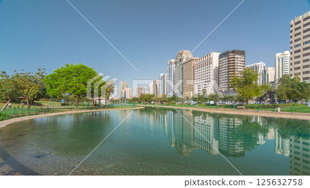 Corniche boulevard beach park along the coastline in Abu Dhabi timelapse hyperlapse with skyscrapers on background. 125632758