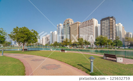 Corniche boulevard beach park along the coastline in Abu Dhabi timelapse hyperlapse with skyscrapers on background. Corniche boulevard beach park along the coastline in Abu Dhabi timelapse hyperlapse with skyscrapers on background. 125632759