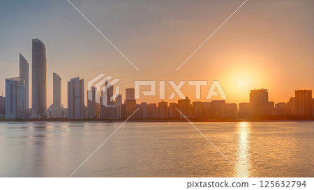 Abu Dhabi city skyline on sunrise time with water reflection timelapse. 125632794