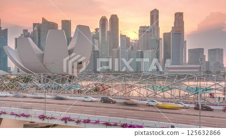 Aerial view of sunset over Helix Bridge and Bayfront Avenue with traffic timelapse at Marina Bay, Singapore 125632866