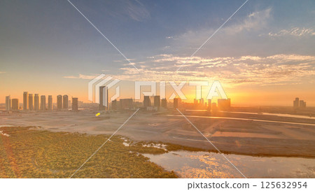 Buildings on Al Reem island in Abu Dhabi at sunset timelapse from above. 125632954