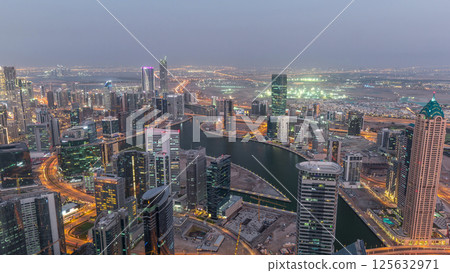 Panoramic aerial view of business bay towers in Dubai day to night timelapse. Panoramic aerial view of business bay towers in Dubai day to night timelapse. 125632971
