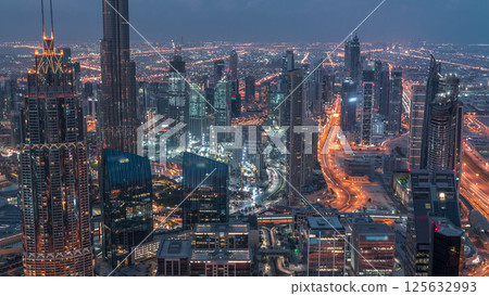 Dubai Downtown skyline futuristic cityscape with many skyscrapers and Burj Khalifa aerial night to day timelapse. 125632993