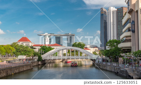Skyline of Singapore financial district behind Elgin Bridge and the Singapore River timelapse hyperlapse 125633051