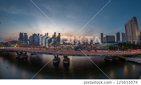 Aerial view over Helix Bridge and Bayfront Avenue with traffic day to night timelapse at Marina Bay, Singapore 125633074