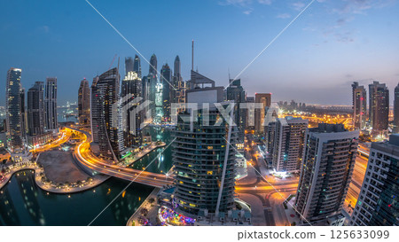 Aerial view of Dubai Marina residential and office skyscrapers with waterfront night to day timelapse 125633099