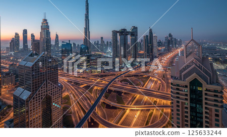 Dubai downtown skyline with tallest skyscrapers and busiest traffic on highway intersection night to day timelapse 125633244