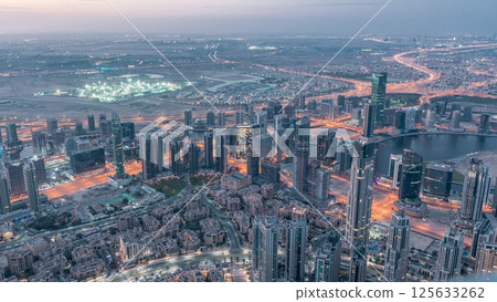 Downtown of Dubai night to day timelapse before sunrise. Aerial view with towers and skyscrapers Downtown of Dubai night to day timelapse before sunrise. Aerial view with towers and skyscrapers 125633262