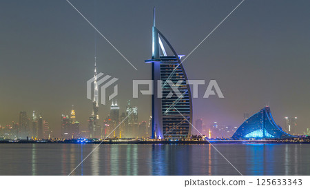 Skyline of Dubai by night with Burj Al Arab from the Palm Jumeirah timelapse hyperlapse. 125633343