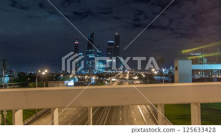 Skyscrapers and transport metropolis timelapse hyperlapse, traffic and lights of cars on multi-lane highways and road junction 125633428