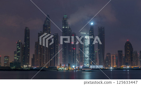 Panorama of modern skyscrapers in Dubai city night to day timelapse from the Palm Jumeirah Island. Panorama of modern skyscrapers in Dubai city night to day timelapse from the Palm Jumeirah Island. 125633447
