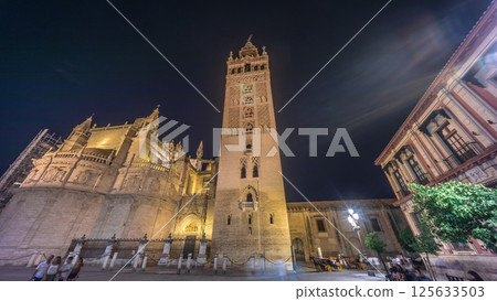 La Giralda and Seville Cathedral timelapse hyperlapse glowing under the night sky. La Giralda and Seville Cathedral timelapse hyperlapse glowing under the night sky. 125633503