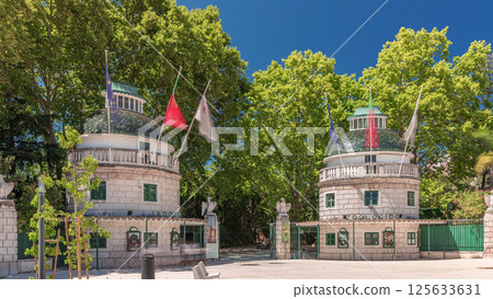 Timelapse hyperlapse of Lisbon Zoo entrance with open gates and flags on towers during summer. Lisbon, Portugal 125633631