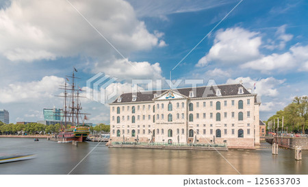 Hyperlapse of the National Maritime Museum with the sailboat replica Amsterdam docked nearby. Amsterdam, Netherlands 125633703