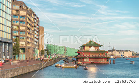 Hyperlapse of pagoda on the water, set against the backdrop of historical city center architecture at sunset timelapse. Amsterdam, Netherlands Hyperlapse of pagoda on the water, set against the backdrop of historical city center architecture at sunset timelapse. Amsterdam, Netherlands 125633706