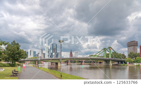 Hyperlapse of Frankfurt's Main Iron Footbridge against the financial district skyscrapers skyline on a sunny day with clouds timelapse. Frankfurt, Germany 125633766