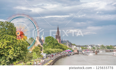 Aerial hyperlapse of pleasure boats on the Rhine Main, framed by the spire of Kaiserdom St. Bartholomaus. Germany 125633778