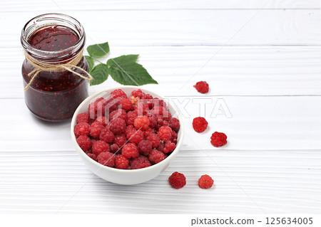 Village harvest, jars of raspberry jam on light wooden background with leaves, shop banner and advertisement, healthy natural food concept, breakfast with ingredients, home canning concept, selective Village harvest, jars of raspberry jam on light wooden background with leaves, shop banner and advertisement, healthy natural food concept, breakfast with ingredients, home canning concept, selective 125634005