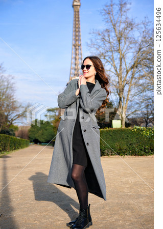 Stylish woman looking away near Eiffel Tower on spring day 125634496