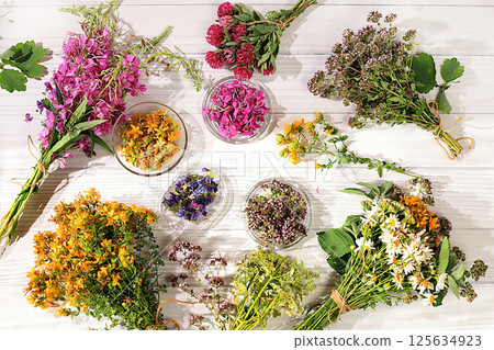 Floral arrangement of wild medicinal herbs and flowers on a wooden table, a bouquet of Hypericum, oregano, fireweed, mint, celandine, chamomile and yarrow, a collection of useful herbs 125634923