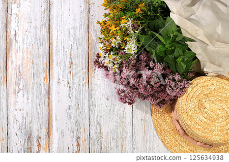 A flower arrangement of wild medicinal herbs on a wooden table in a canvas eco-friendly bag, a bouquet of St. John's wort, oregano, mint, chamomile, a collection of useful herbs . 125634938