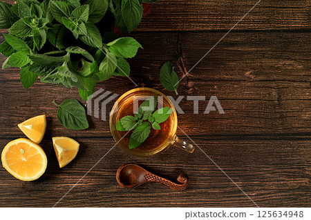 Medicinal herbal tea or infusion of peppermint with lemon with flowers, concept of alternative traditional medicine, collection of useful herbs for treatment according . 125634948