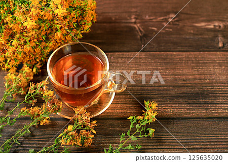 Medicinal herbal tea or oregano infusion in a glass cup with flowers, the concept of alternative traditional medicine, green pharmacy advertising, collection of healthy herbs for treatment according Medicinal herbal tea or oregano infusion in a glass cup with flowers, the concept of alternative traditional medicine, green pharmacy advertising, collection of healthy herbs for treatment according 125635020