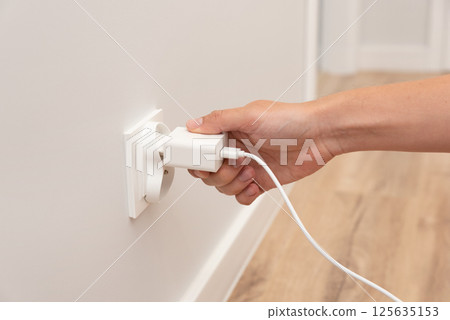 Man plug charger into smart socket Man plug charger into smart socket 125635153