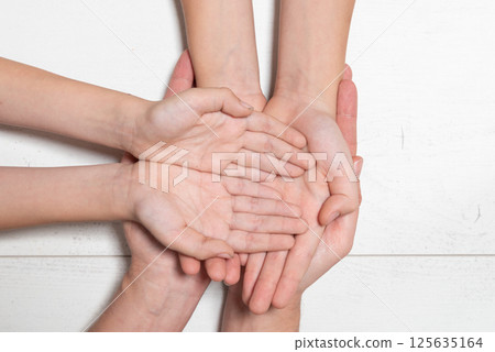 A group of hands are clasped together and unity A group of hands are clasped together and unity 125635164