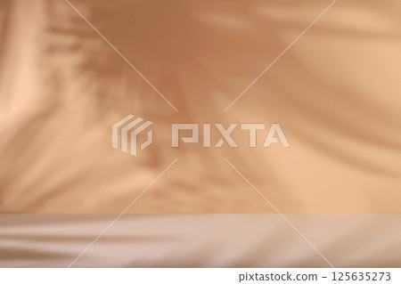 Minimal abstract background for cosmetic products presentation.Empty premium podium with shadows of tropical palm leaves on beige wall,template for design,pedistal display podium,selective focus 125635273