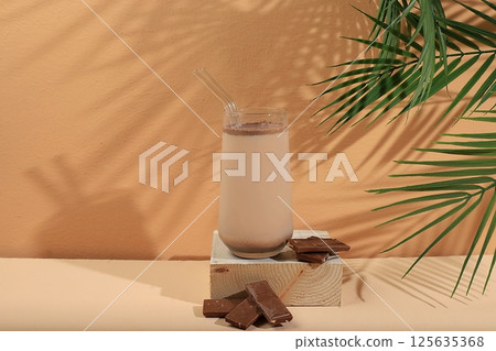 Coffee drink with milk and dark chocolate,lassi,cocktail.Modern still life on a pastel background with long hard shadows,minimal concept,traditional breakfast drink rich in antioxidants,selective 125635368