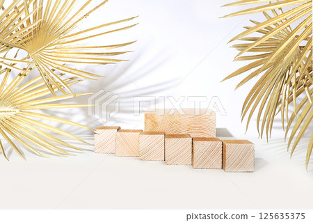 Modern abstract background with natural wood podiums and golden palm leaves, empty showcase for advertising or presentation of cosmetic products, stage with geometric shapes, selective focus 125635375