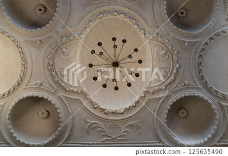 Look up at A stunning chandelier hanging on The ceilings are made of plaster is carved into a dome shape. 125635490