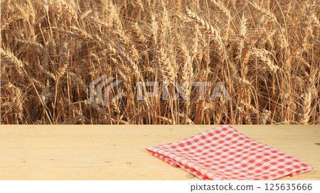 Empty wooden rustic table on the background of a wheat field, the concept of harvesting. Jewish holiday of Shavuot, mockup for design and product demonstration, selective focus 125635666