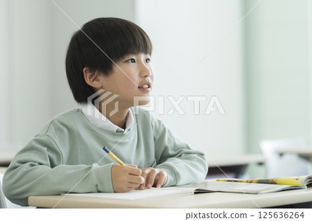 A fourth grade boy studying 125636264