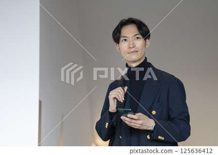 A man in his thirties with a smartphone 125636412