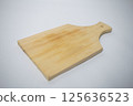 Natural wood chopping board with a handle, ideal for slicing vegetables or serving cheese. 125636523